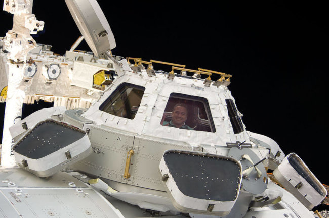 1024px-STS-130_George_Zamka_looks_through_the_Cupola