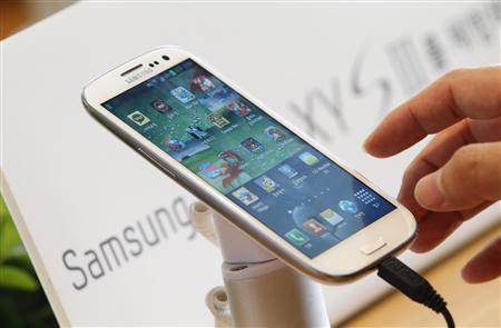 File photo of a man trying Samsung Electronics' new Galaxy S III smartphone that is on display at a store in Seoul