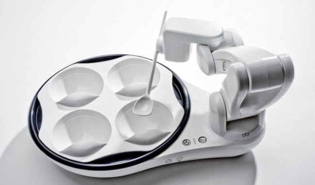 Obi – робот, помогающий людям с ограниченными возможностями принимать пищу. Obi – робот, помогающий людям с ограниченными возможностями принимать пищу. Фото.