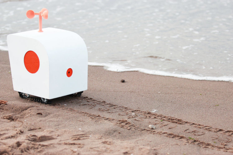 Чувственный робот-поэт слушает чаек и пишет стихи на песке. Фото.