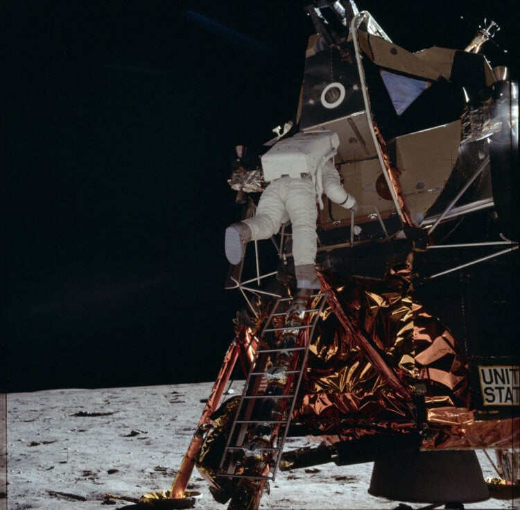 Первая высадка на Луну — «Аполлон-11». Астронавт NASA Базз Олдрин спускается по лестнице Лунного модуля готовясь ступить на лунный грунт, Аполлон 11, 1969. Фото.