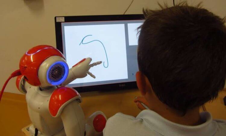 Как научить ребенка писать? Робот NAO и ученик португальской школы. Фото.