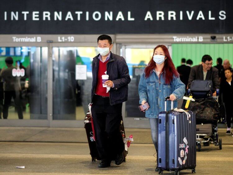 Откуда в Китае коронавирус? На фото пассажиры в защитных масках в аэропорту Харбина 11 апреля. Фото.