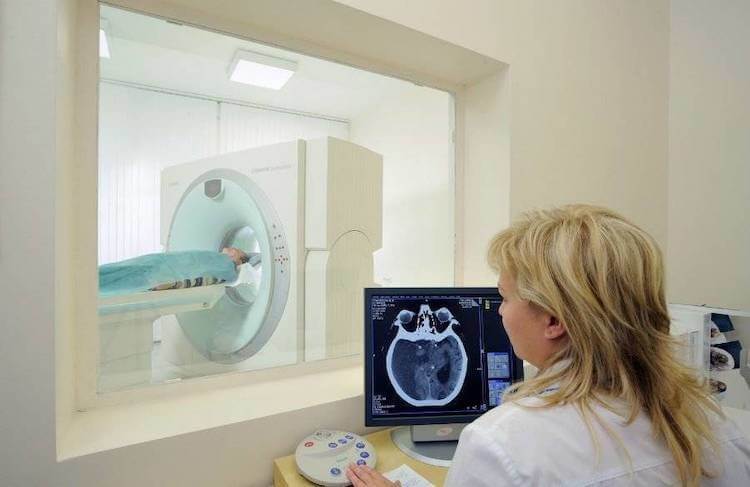 КТ головы и головного мозга. Как и при рентгене, во время проведения КТ специалист сидит в отдельной комнате. Фото.