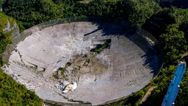 Почему рухнула Аресибо? Сотрудники обсерватории Аресибо считают, что 1 декабря один из оставшихся подвесных тросов оборвался, и 900-тонная приборная платформа врезалась в тарелку. Фото.