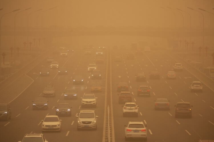 Сильнейшая за последние 10 лет песчаная буря. Автомобили движутся по дороге во время песчаной бури в Пекине, 15 марта 2021 года. Фото.