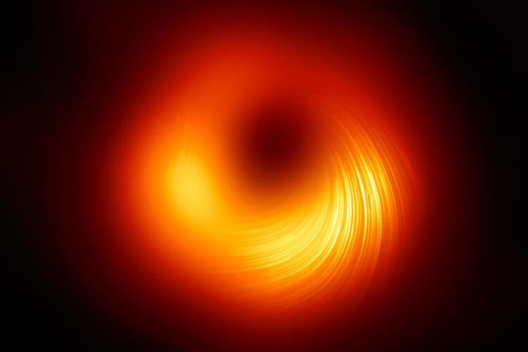 Получена новая фотография черной дыры. Что в ней особенного? Вид на сверхмассивную черную дыру в поляризованном свете. Изображение: EHT. Фото.