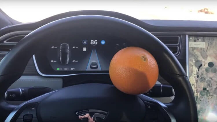 Как обмануть автопилот Tesla? А после трюка с апельсином автомобиль считает, что руки водителя лежат на рулевом колесе. Фото.