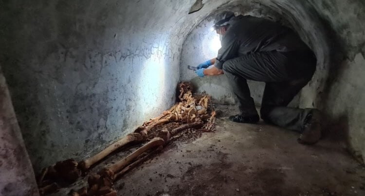 Мумия в Помпеях. Исследователь внутри гробницы с мумией. Фото.