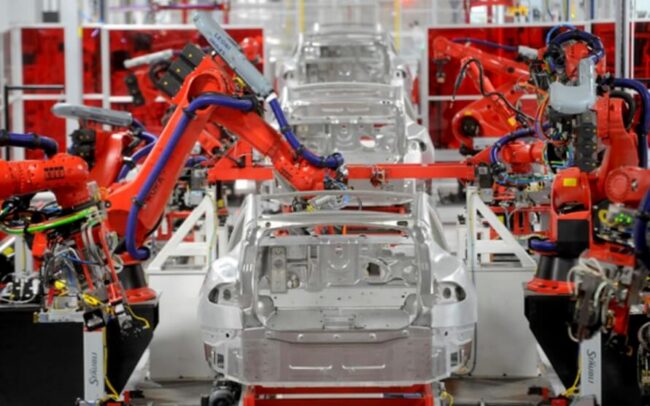 Роботы-манипуляторы собирают автомобили Tesla. Фото.