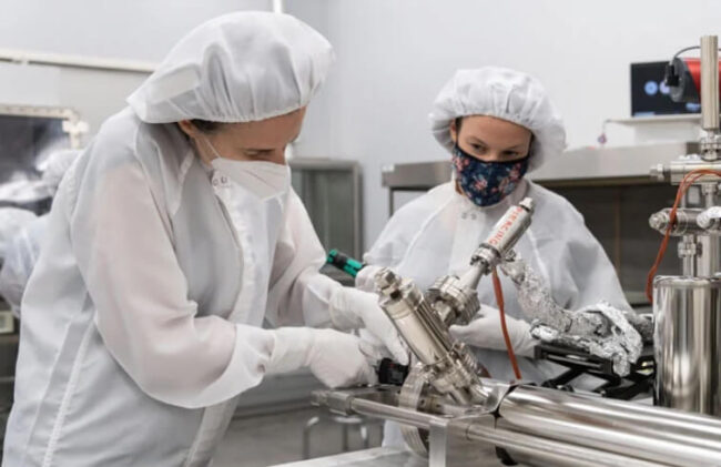 Ученые проделывают отверстие в пробирке с лунным грунтом. Фото.