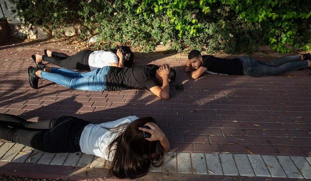 Как вести себя при обстреле на улице. При обстреле необходимо лечь на землю и обхватить голову руками. Фото.