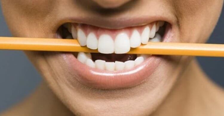 Изучение влияния улыбки на настроение. Удерживая карандаш в зубах, можно имитировать улыбку. Фото.