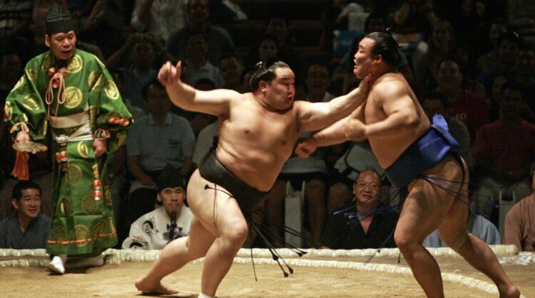 Где происходят поединки сумо. Сумоист дает пощечину своему оппоненту. Фото.