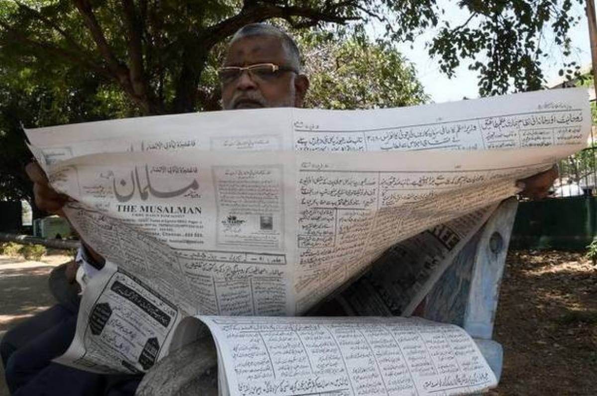 Газеты с рукописным текстом. Мужчина читает газету Musalman. Фото.