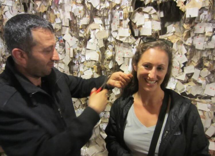 Музей волос в Турции. Мужчина берет прядь волос у посетительницы музея. Фото.