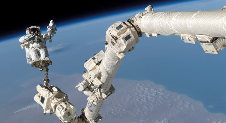 Канадские технологии в космосе. Роботизированная рука Canadarm2 и космонавт. Фото.