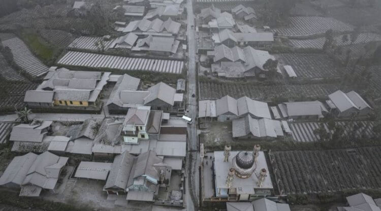 Извержение вулкана Мерапи в 2023 году. Вид сверху на дома, покрытые пеплом вулкана. Фото.