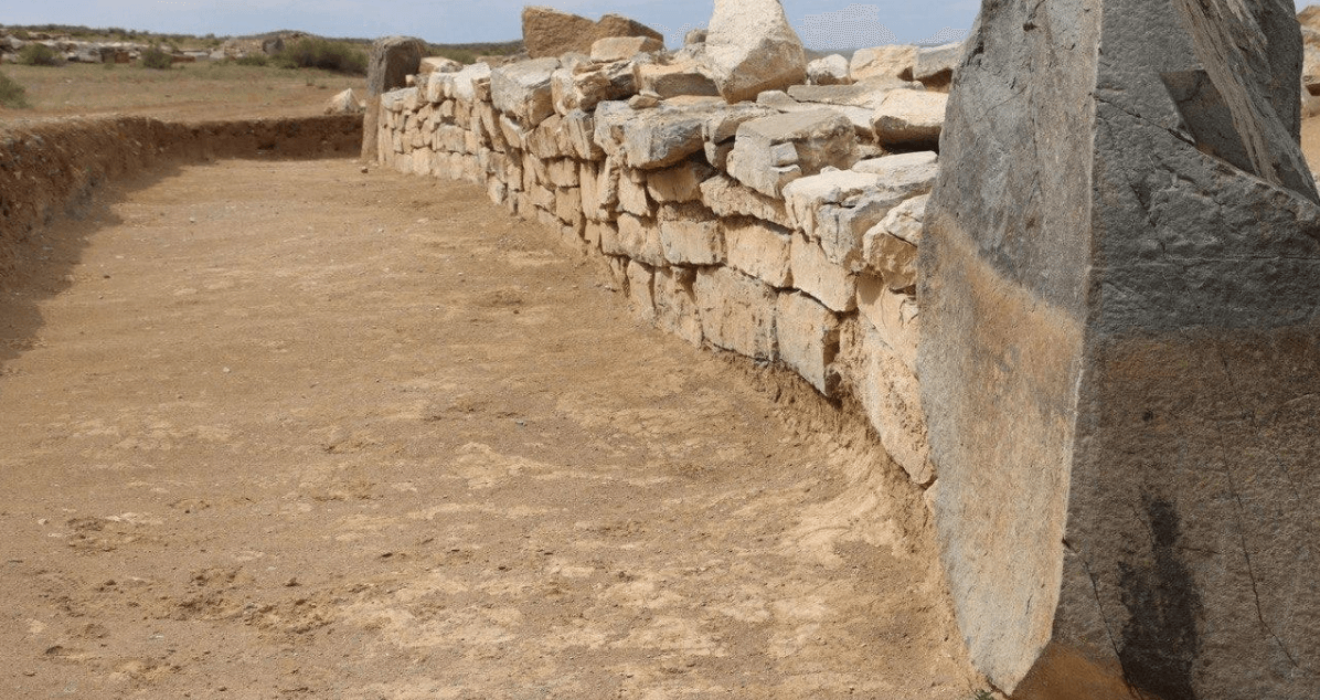 Артефакты внутри каменного сооружения. Внешние стены шестиугольного сооружения. Фото.