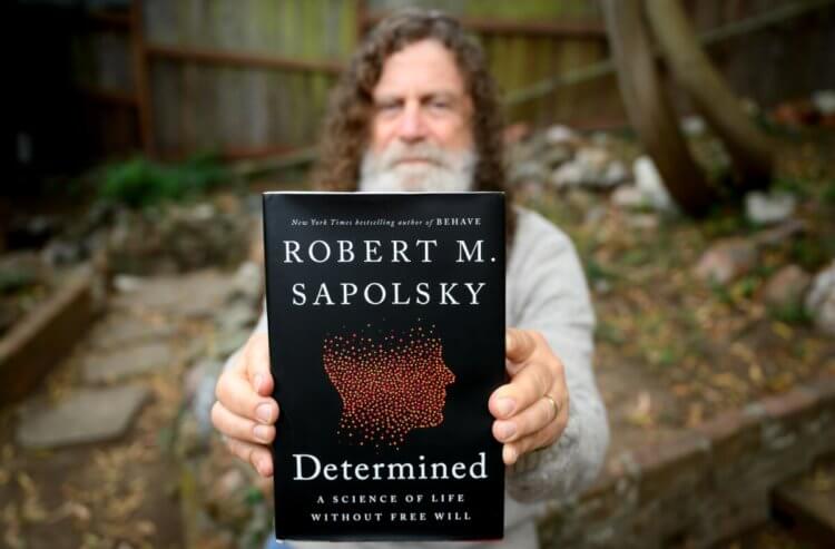 Роберт Сапольски и поведение человека. Роберт Сапольски держит в руках свою новую книгу. Фото.