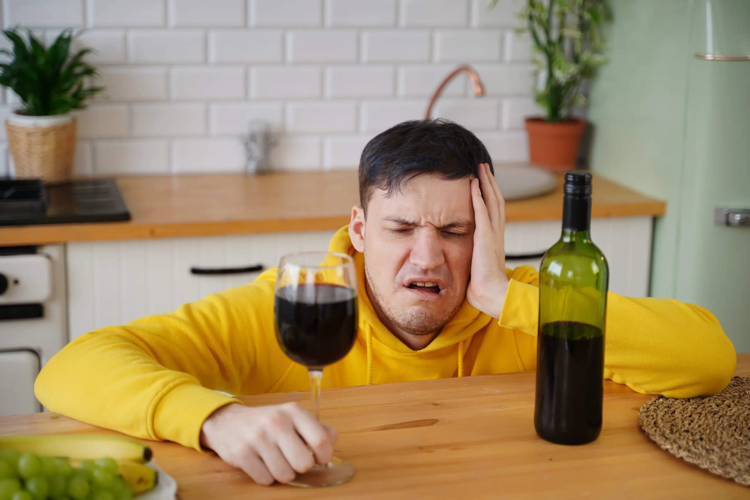 Красное вино болит голова. Головная боль от красного вина. Мужчина с бокалом красного вина. Выпил вина болит голова. У мужчины болит голова.