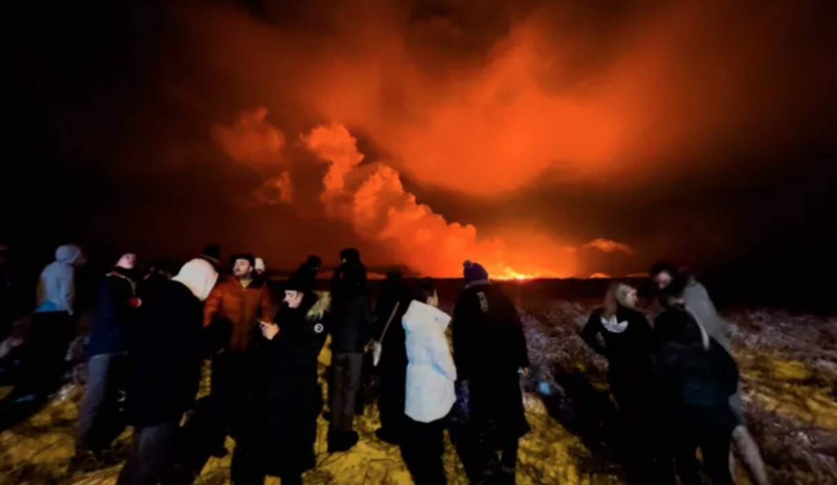 Извержение вулкана в Исландии в 2023 году. Люди наблюдают за извержением вулкана. Источник фотографии: The Guardian. Фото.