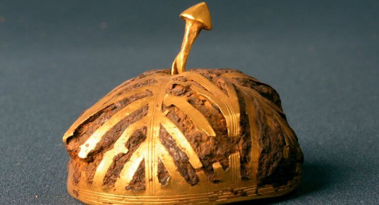Археологическая находка из необычного металла. Железная полусфера, украшенная золотом. Фото.