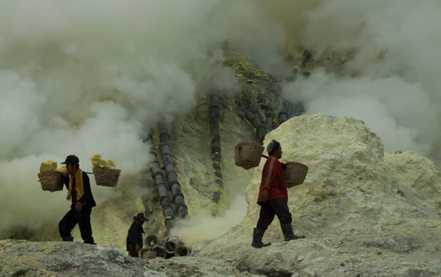 Добыча серы на вулкане Иджен. На месте работы этих людей ужасно пахнет сероводородом. Источник: yalejournal.org. Фото.