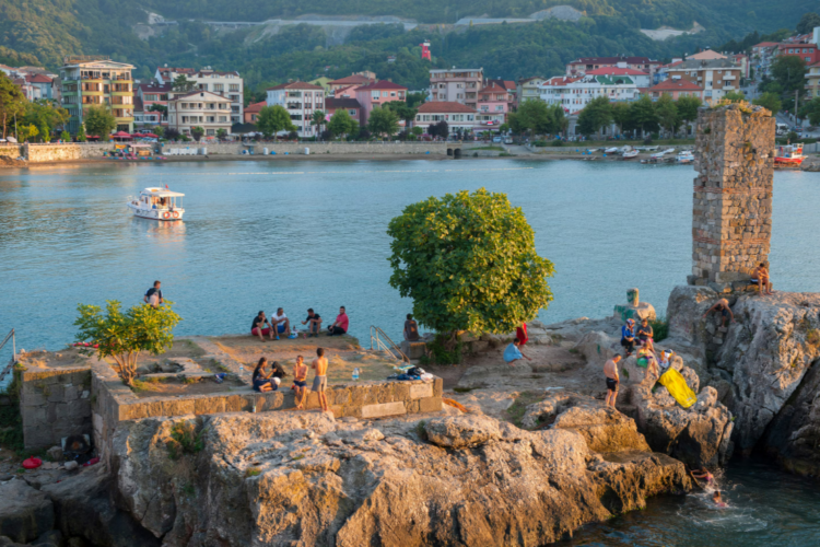 Черноморское побережье Турции: куда поехать и что посмотреть. В Амасре, Турция, туристы и местные жители собираются на Дирекли Кая (скала-столб), чтобы искупаться в Черном море. Источник изображения: nationalgeographic.com. Фото.