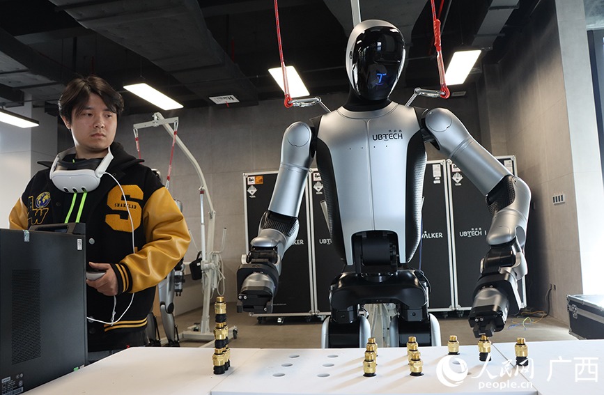 Робот тренируется под руководством инструктора на заводе Dongfeng Liuzhou Motor. Источник изображения: en.people.cn. Фото.