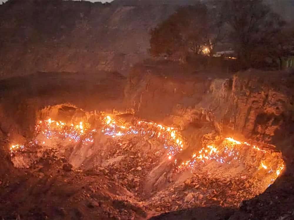 Угольное месторождение горит под деревней в Джарии, Индия. Фото.