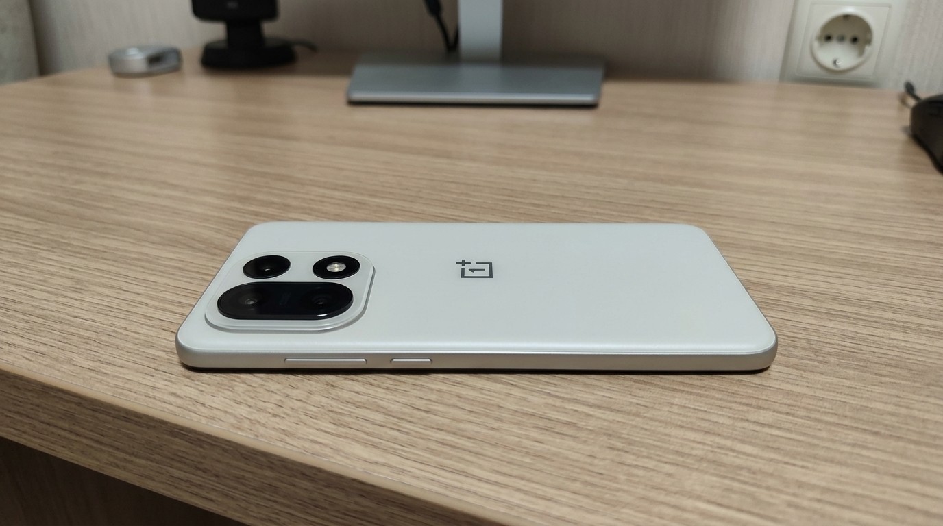 Смартфон OnePlus 15 задней панелью на столе