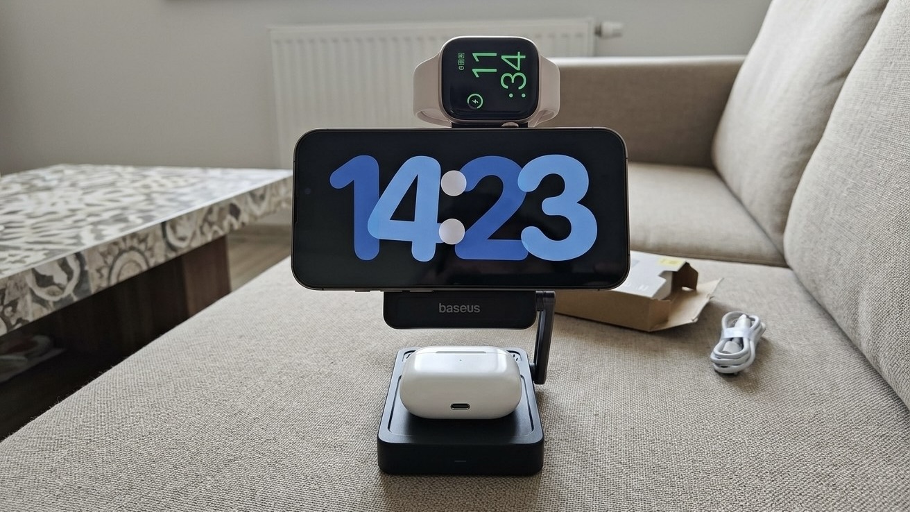 Зарядная станция Baseus 3-в-1 на диване, на ней заряжаются iPhone с часами в режиме ожидания, Apple Watch и AirPods Pro