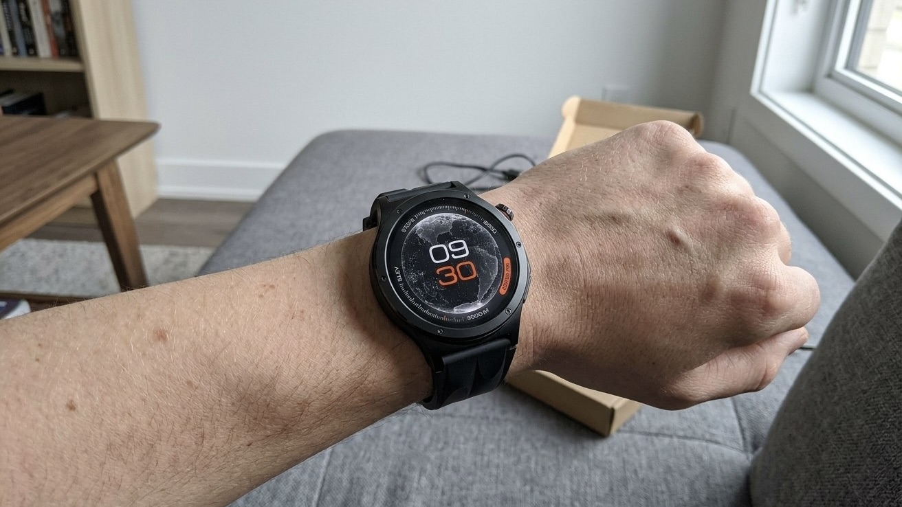 Часы OnePlus Watch 4 с черным ремешком и оранжевыми цифрами на циферблате на запястье