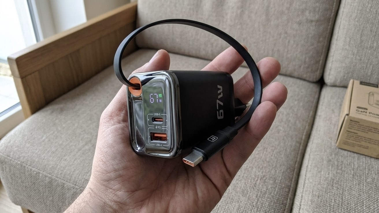 Зарядное устройство Toocki на 67 Вт со встроенным кабелем USB-C в руке, на экране горят цифры 67 W